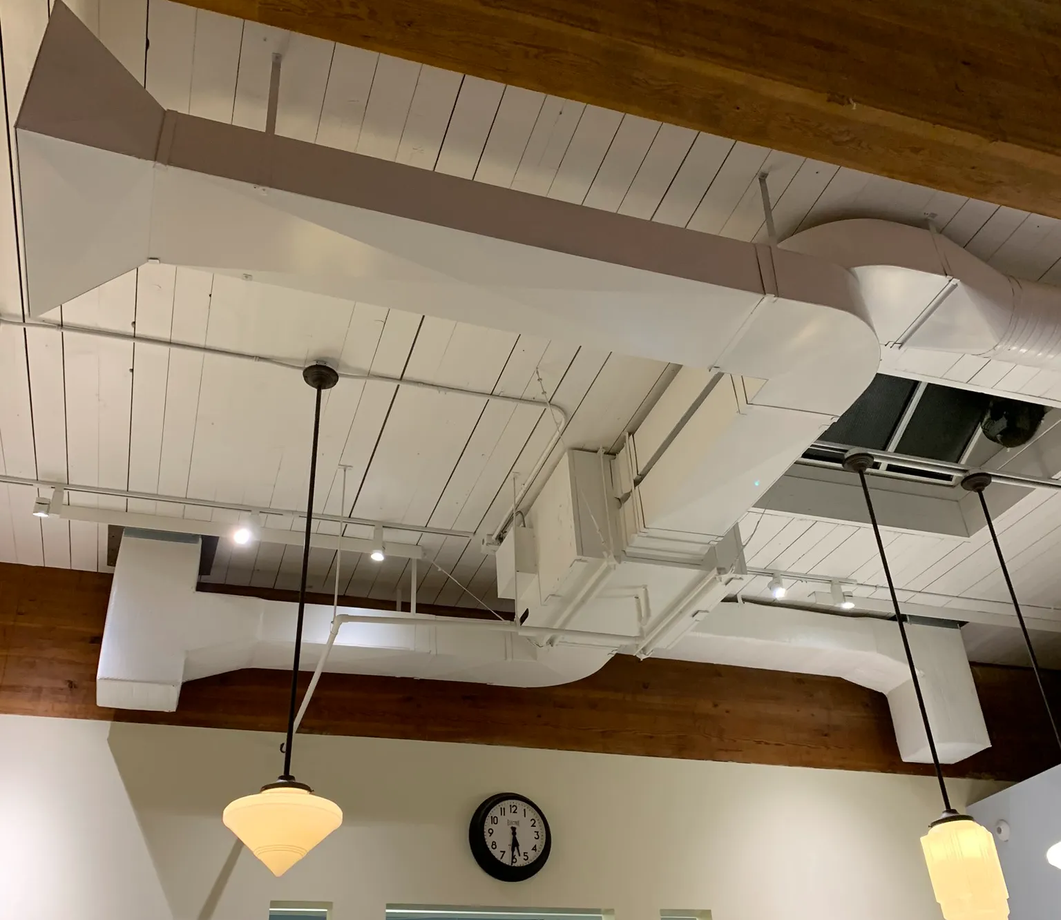 White exposed ductwork and ventilation system in commercial bakery ceiling