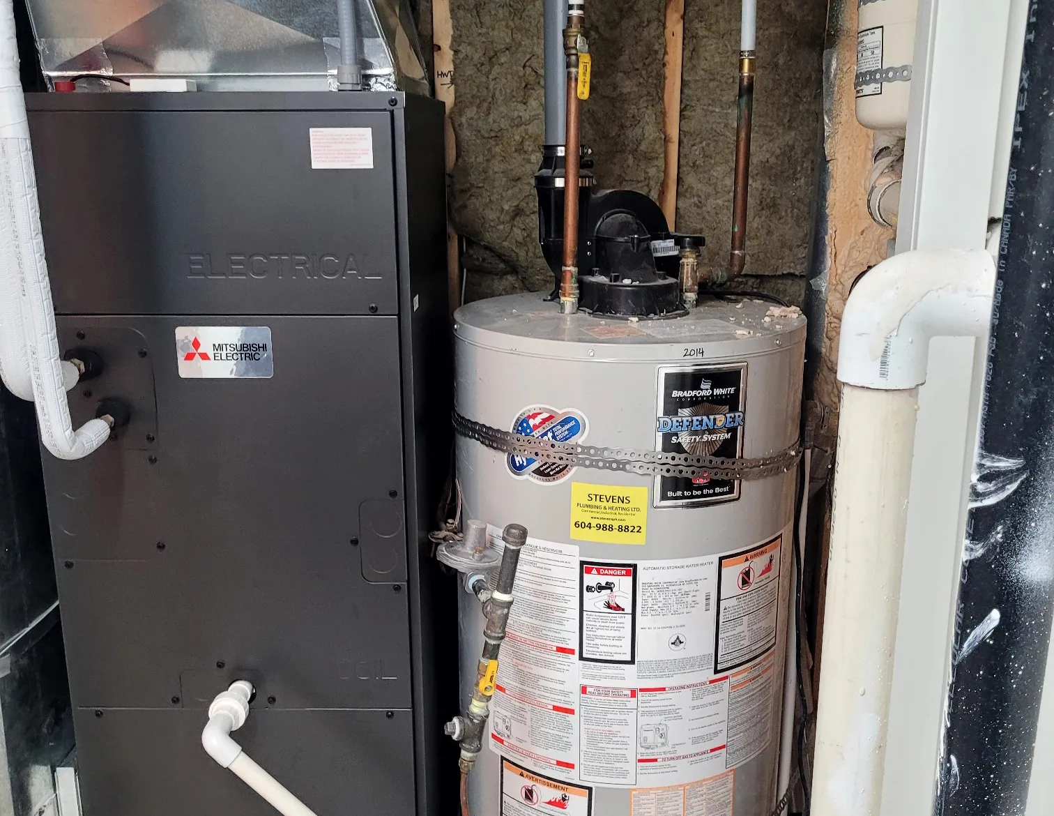 Mitsubishi Electric air handler and Bradford White water heater installed in tight residential mechanical room