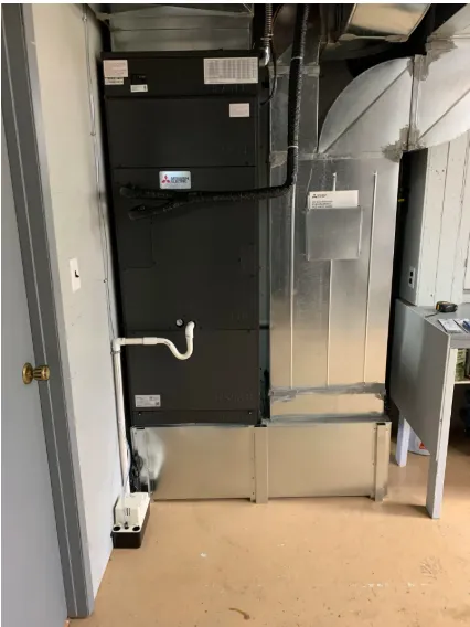 Mitsubishi Electric indoor air handler unit installed in mechanical room with ductwork connections