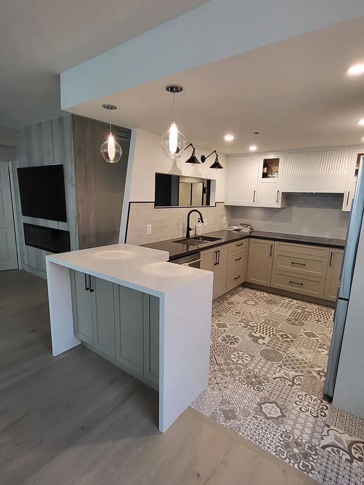 Renovated kitchen with white island, patterned tile floor, pendant lights, and two-tone cabinetry